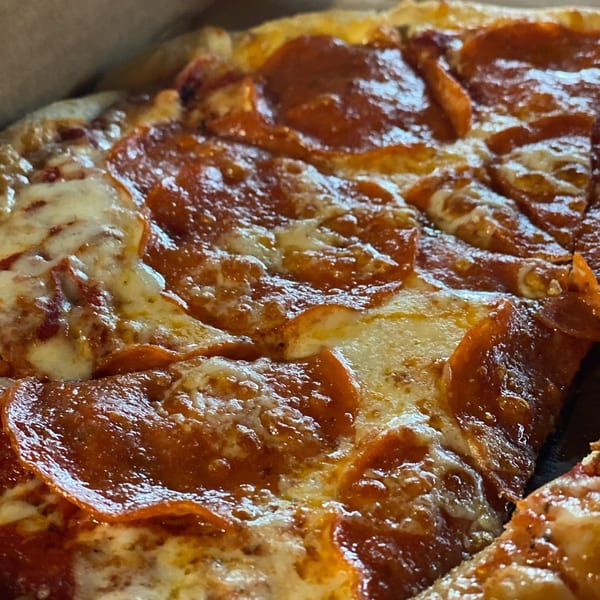 Close-up of a pepperoni pizza from The Mill House, with melted cheese and crispy crust.