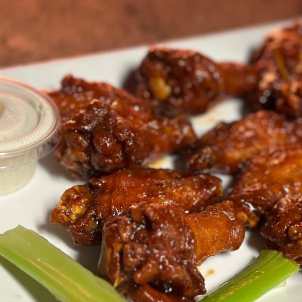 The Mill House's glazed chicken wings with celery sticks and a side of ranch dressing.